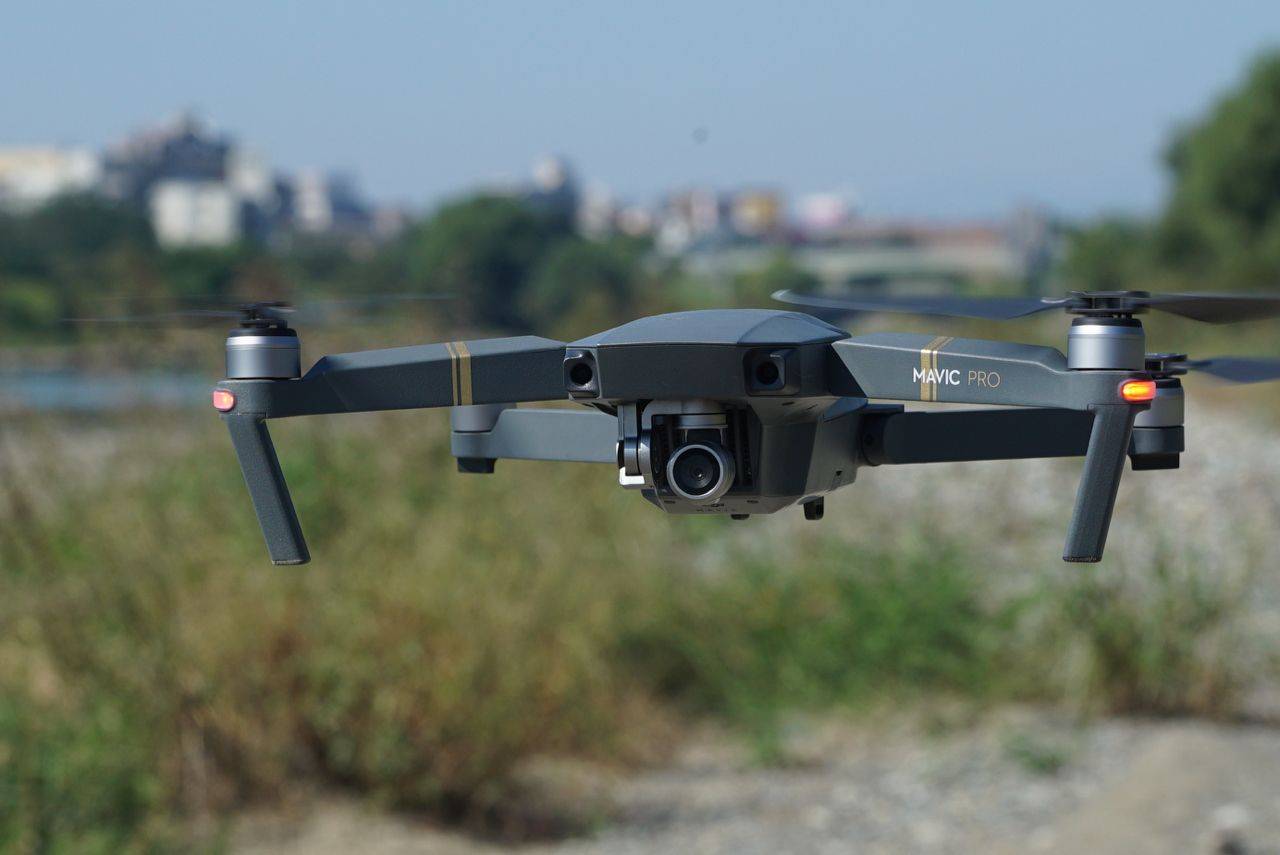 Drone oscuro volando sobre hierba