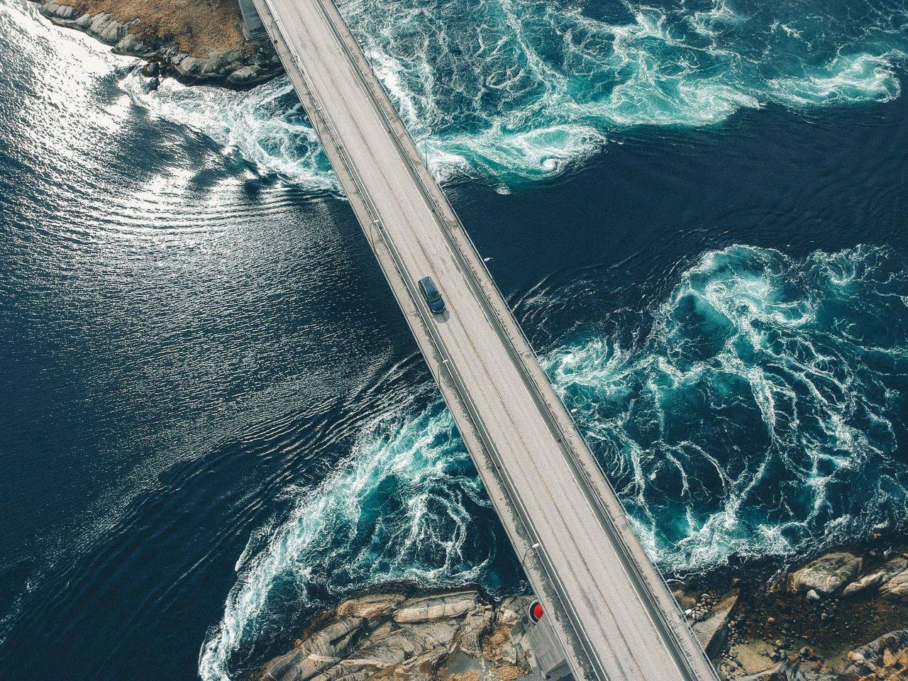 auto en un puente sobre un rio azul