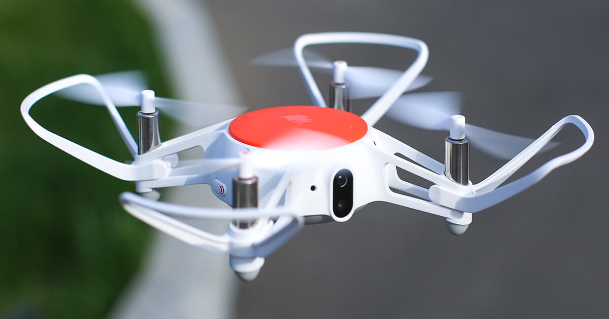Mini drone blanco y naranja volando