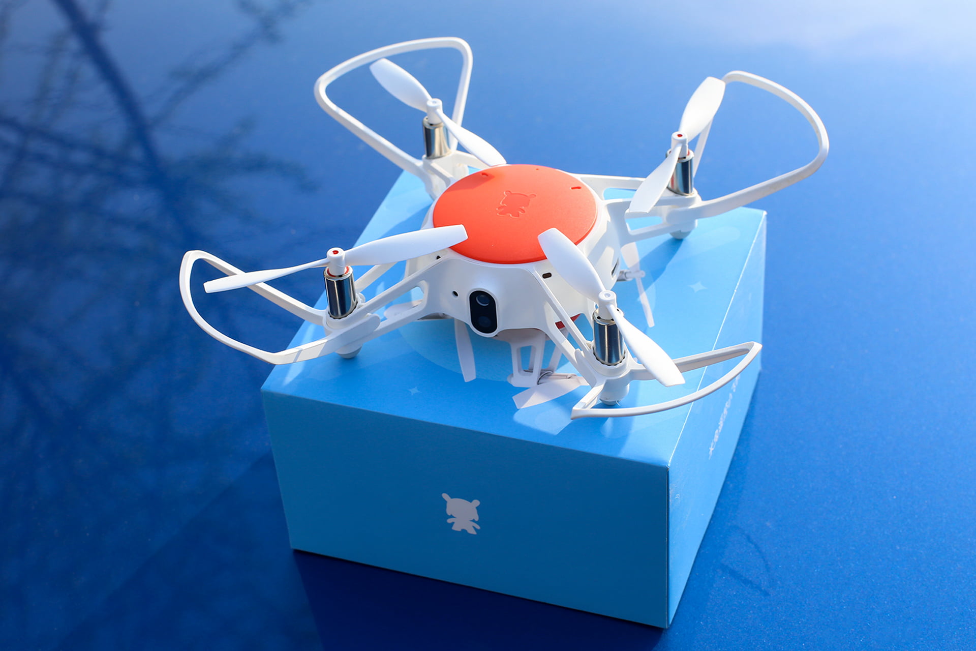 Mini drone sobre caja y fondo azul